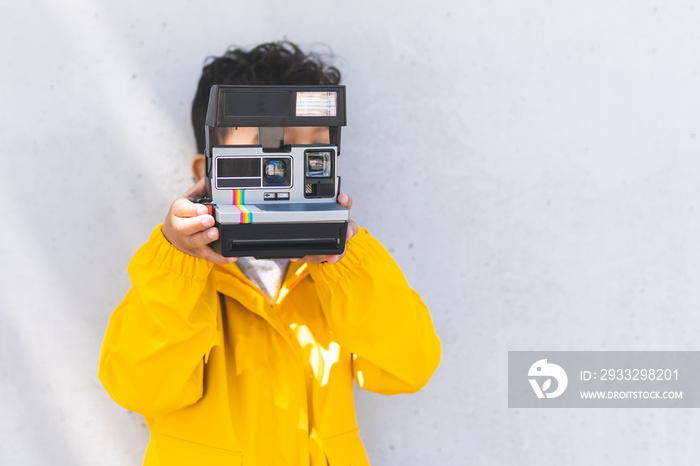 Child Boy Using Instant Camera Outdoors.