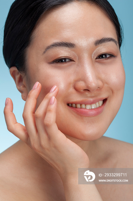 Close-up�of smiling woman touching face