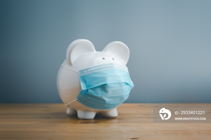 Piggy bank wearing surgical face mask. Global economy during coronavirus pandemic.  Financial crisis