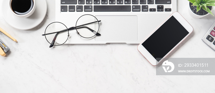 Stylized clean marble office working desk with smartphone, laptop, glasses and coffee cup, workspace