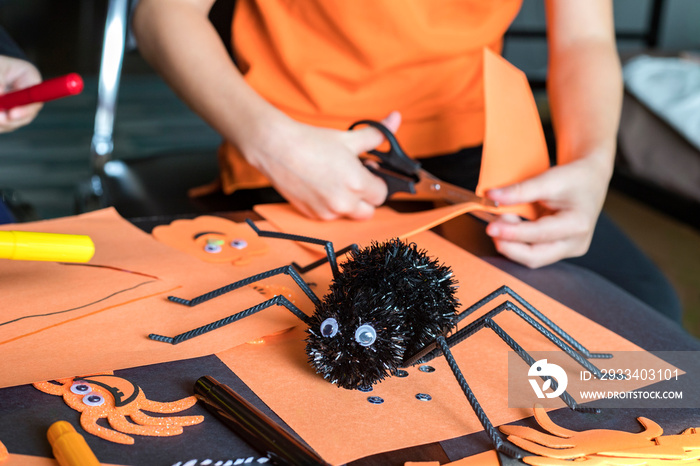 Halloween kids craft preparations. Little children doing  crafts at home. Halloween children party c