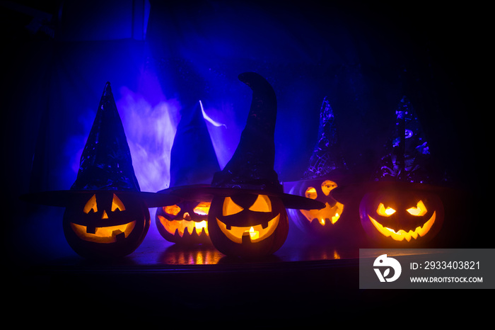 Group of Halloween Jack o Lanterns at night with a rustic dark foggy toned background