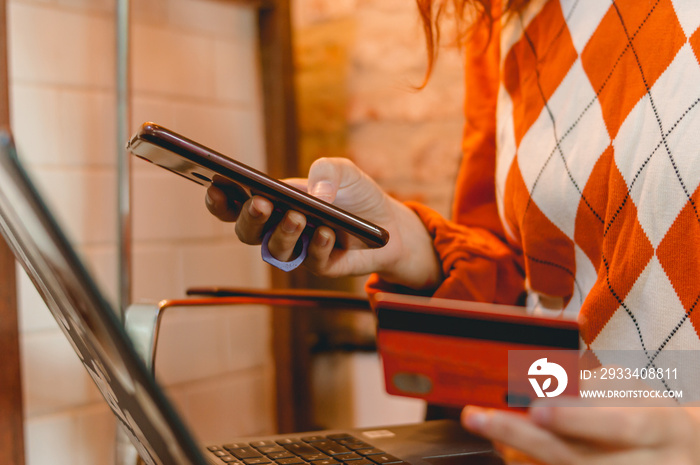 young woman shopping online with laptop, phone and credit card