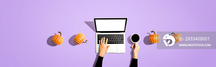 Autumn pumpkins with person using a laptop computer from above