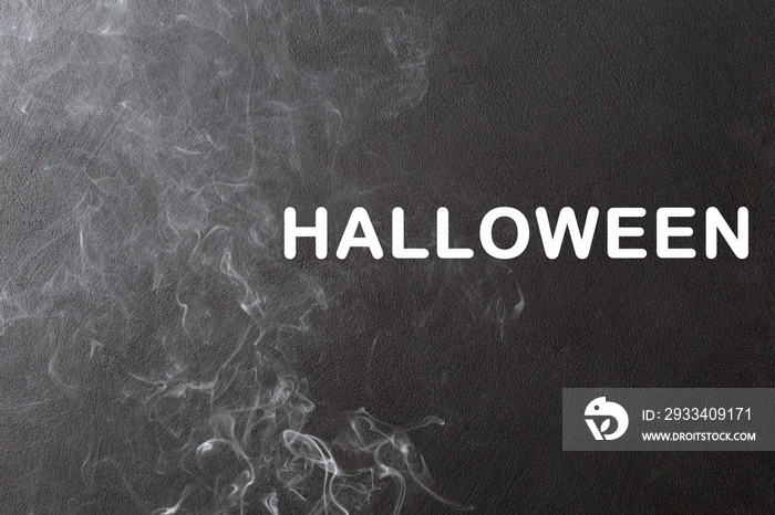 Magical white smoke and the inscription Halloween on a black background