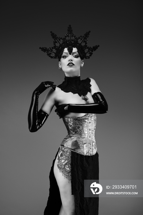 Portrait of a young woman wearing a lace cap, a corset and black latex gloves