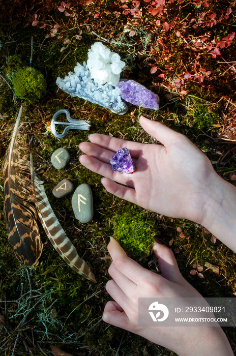 Space with feathers and crystals in the forest. Alternative medicine or esoteric background. Female 