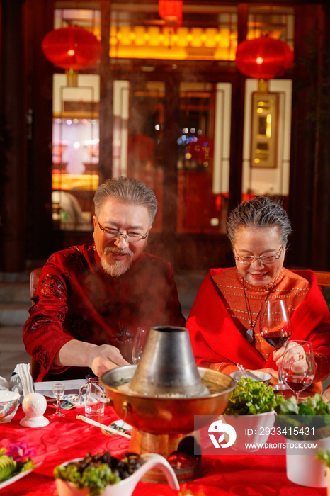 春节东方老年夫妇在中式庭院内聚餐