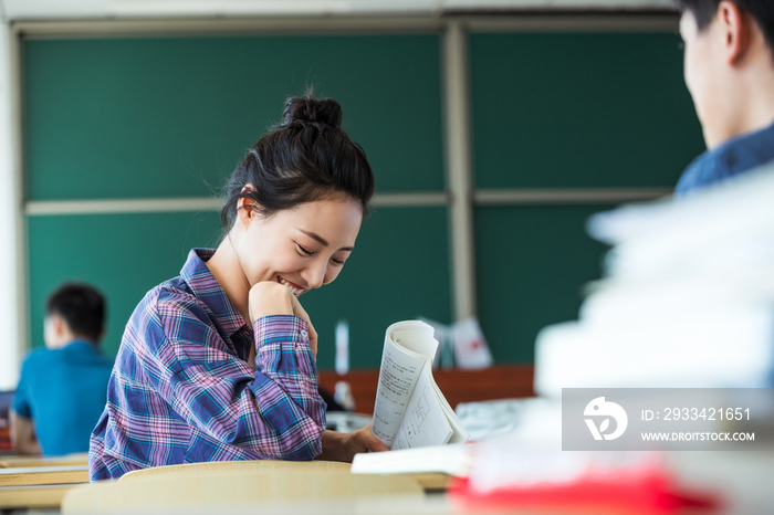 教室里回头讨论学习的大学生