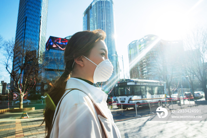 青年女人戴口罩在户外行走