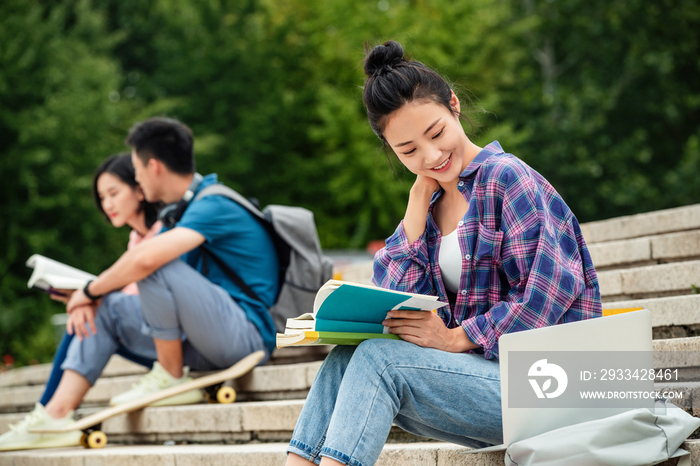 快乐的大学生坐在台阶上学习