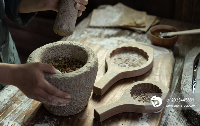 制作月饼的烘焙师用石臼捣碎果仁