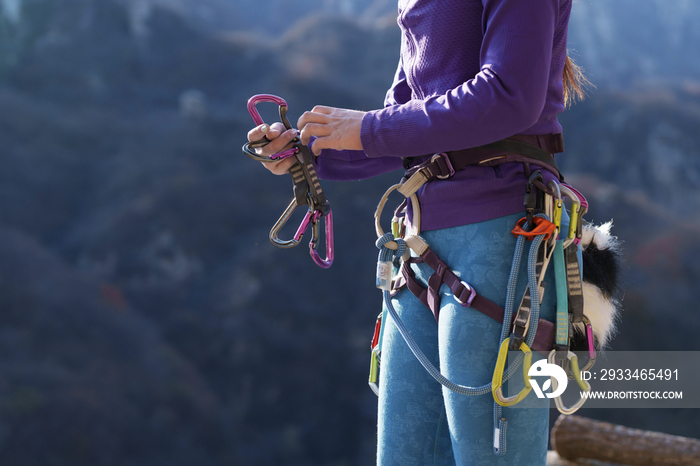 青年女性登山者调整安全设备