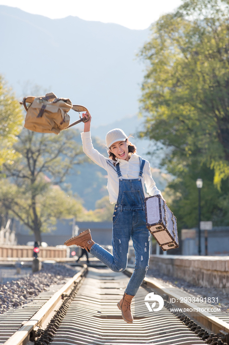 青年女人在铁轨上跳跃