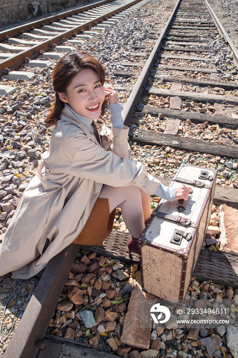 青年女人坐在铁轨上