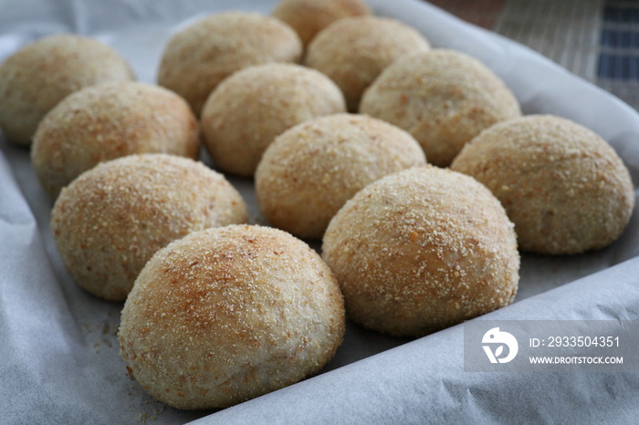 Fresh baked pandesal on parchment paper.