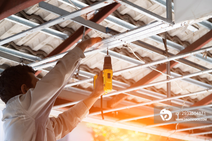 Worker hand injured using electric shovel to repair the roof, work safety concept.