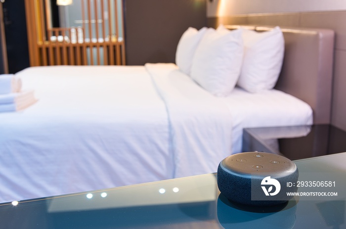 Black Amazon Alexa as Voice recognition device and white coffee mug photographed on glass table and wooden table in bed room with sunlight background