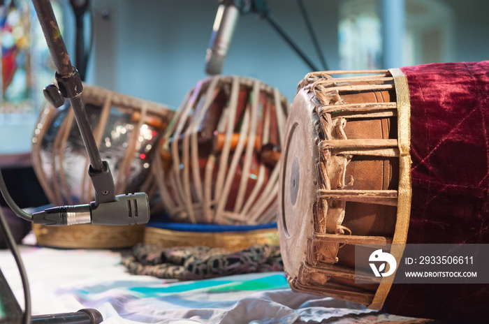 Indian drums, including a tabla and a mrdanga on a stage waiting to be played