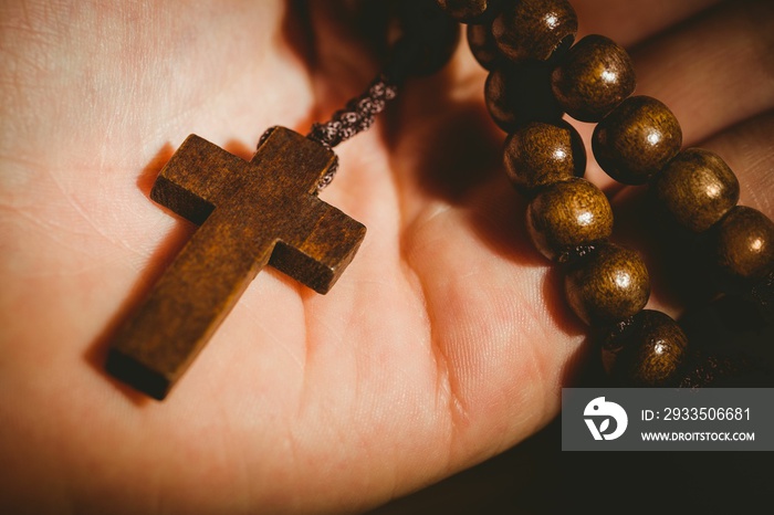 Hand holding rosary beads