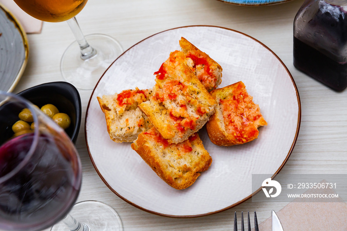 Appetizing Pan con tomate - grilled bread topped with mixture of grated tomatoes with salt and olive oil. Popular Catalan wine tapas.