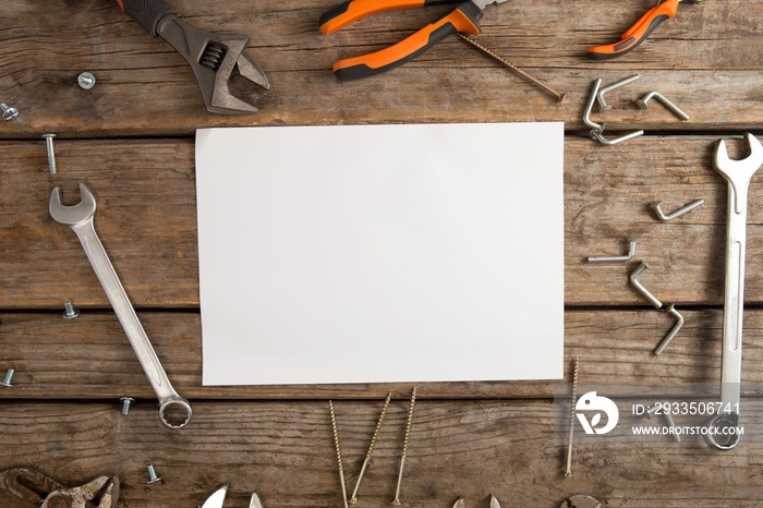 Work tools and blank paper on wooden plank