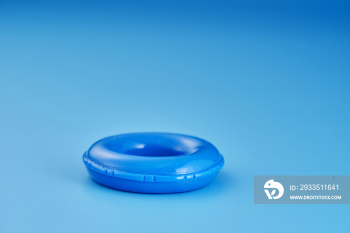 small toy inflatable ring against blue background