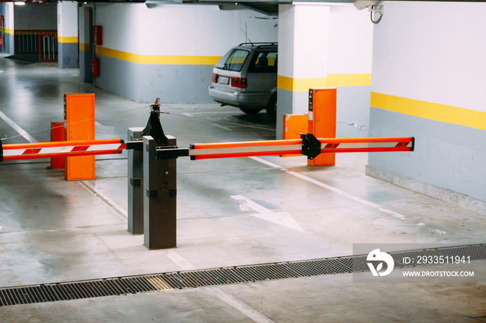 Barrier to an underground parking lot with parked cars