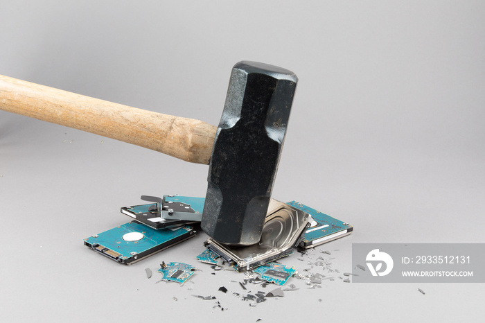 cyber security - computer hard disk drive destruction to prevent data theft with a sledge hammer