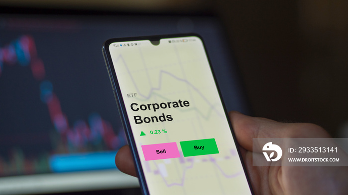 An investor’s analizing the corporate bonds etf fund on a screen. A phone shows the prices of an ETF