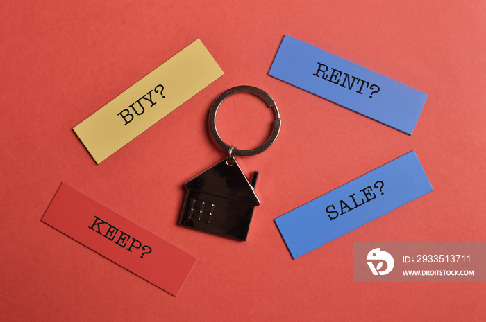 House keychain and memo note written with BUY? RENT? KEEP? SALE?. Property concept.