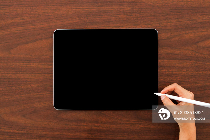 Mock up of digital tablet device with digital pencil in hand on wooden background. Laptop and digital pen connecting wifi.  Flat lay, Top view. Copy space.