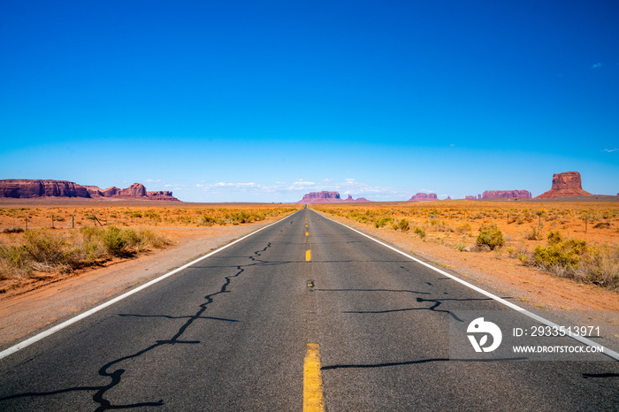 Endless infinite road that goes through the Monument Valley National park with amazing rock formations.