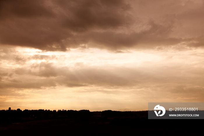 dramatic landscape in backlight with sunset over Roback in Umea with light pillars coming from the sky