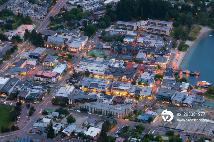 Aerial view of houses, business district street at night in the city center of Queenstown, New Zealand ’s South Island. Real estate, housing and land business.