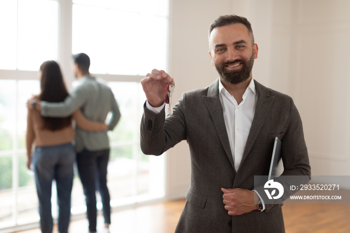 Portrait Of Smiling Real Estate Agent Holding And Showing Key