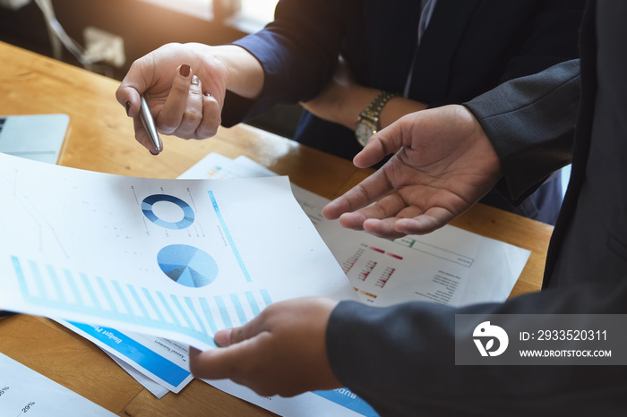 An auditor holds a pen pointing to documents to examine budgets and financial fraud.