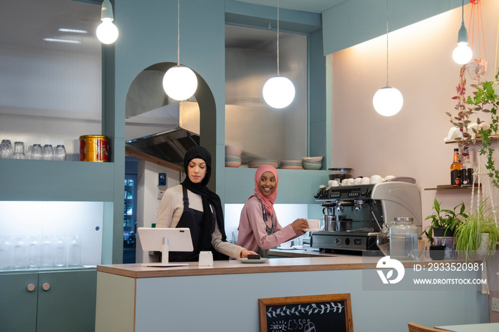 Smiling young women working in cafe