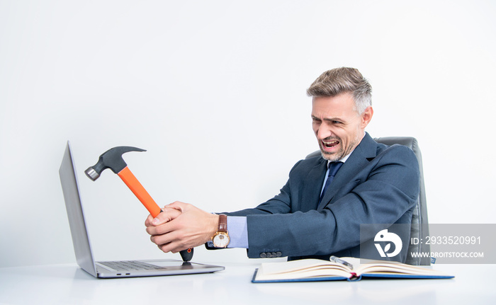 overworked boss hitting laptop with hammer in office