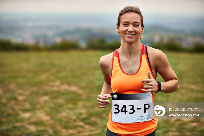 Happy female marathon runner in nature.