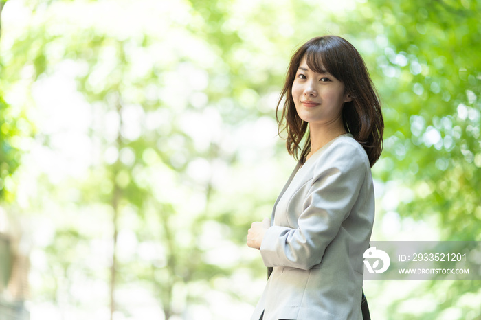 portrait of asian businesswoman walking in sidewalk