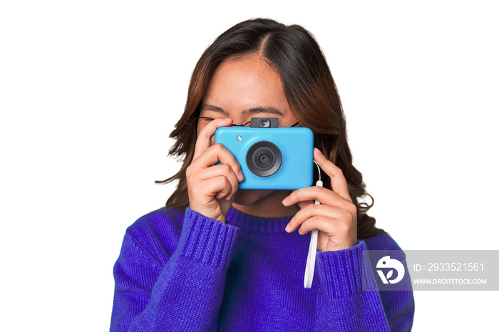 Happy Asian woman holding a retro camera.