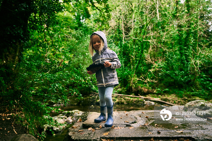 Little preschooler in the forest holding some charcoal