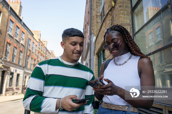 Smiling woman and man looking at smart phone together