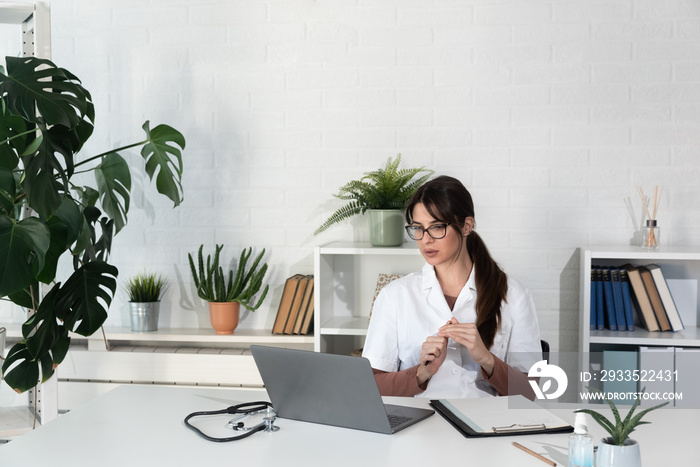 Woman doctor reading email she received from a patient who thanks her for help and informs her that he has recovered. Female health care medical worker using laptop computer for communication.