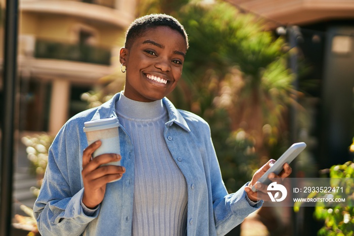 Young african american woman using smartphone and drinking coffee at the city