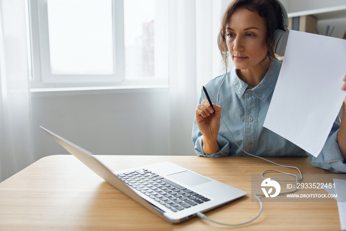 Focused serious self-confident adorable curly businesswoman leader listening colleagues at online meeting with their purposes and questions tells about new startup idea or methods to improving work