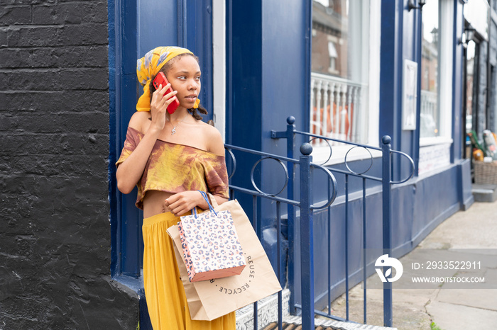 Smiling woman talking by smart phone in city