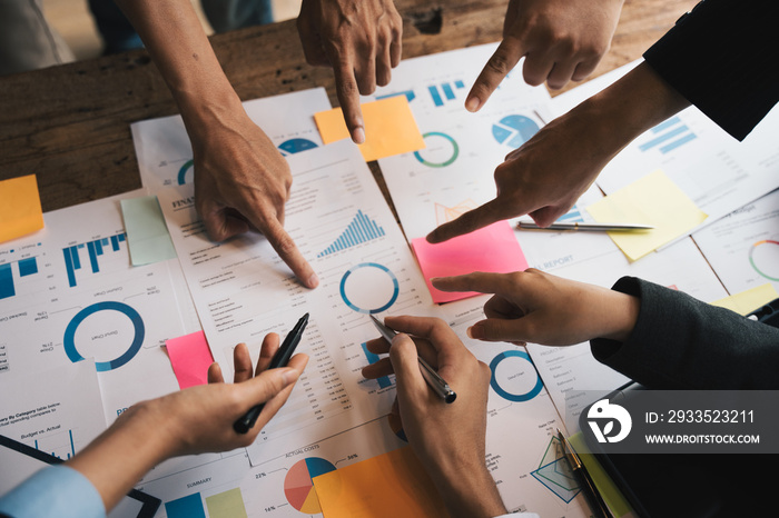 Close-up of Business team hands pointing a pie chart together on the data sheet, statistics and team work concept.