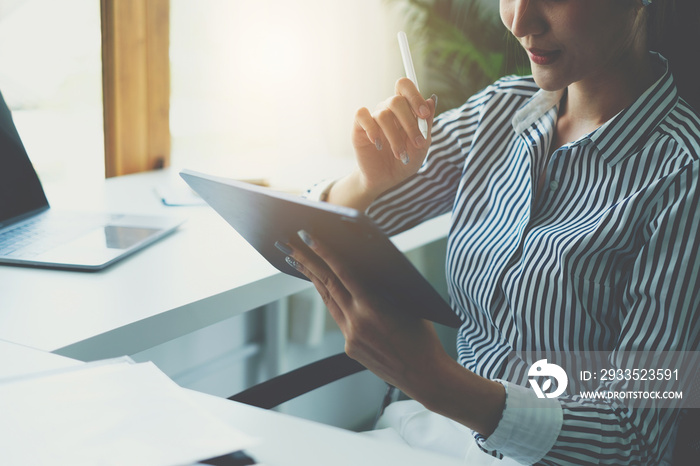 Business woman hand holding pencil looking at bank savings account application on digital tablet. account or saving money or insurance concept.